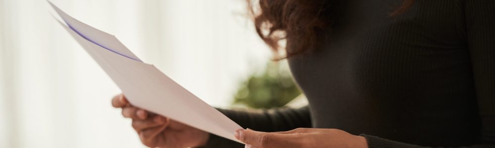 Cropped image of business woman reading documents in her hands